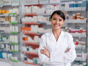 Portrait of a pharmacist working at the drugstore and looking at the camera smiling