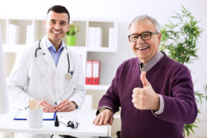 Satisfied old patient with success young doctor in office